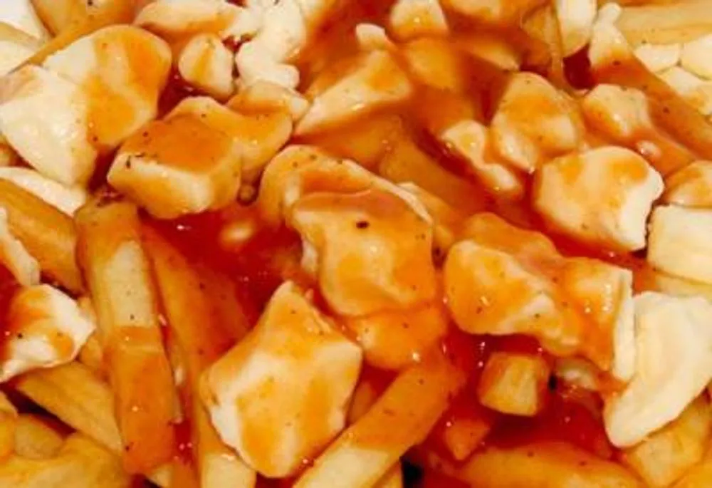 Close-up shot of poutine with crispy fries, cheese curds and rich gravy at Pizzeria 67, a Pizza Restaurant in Grand-Mère
