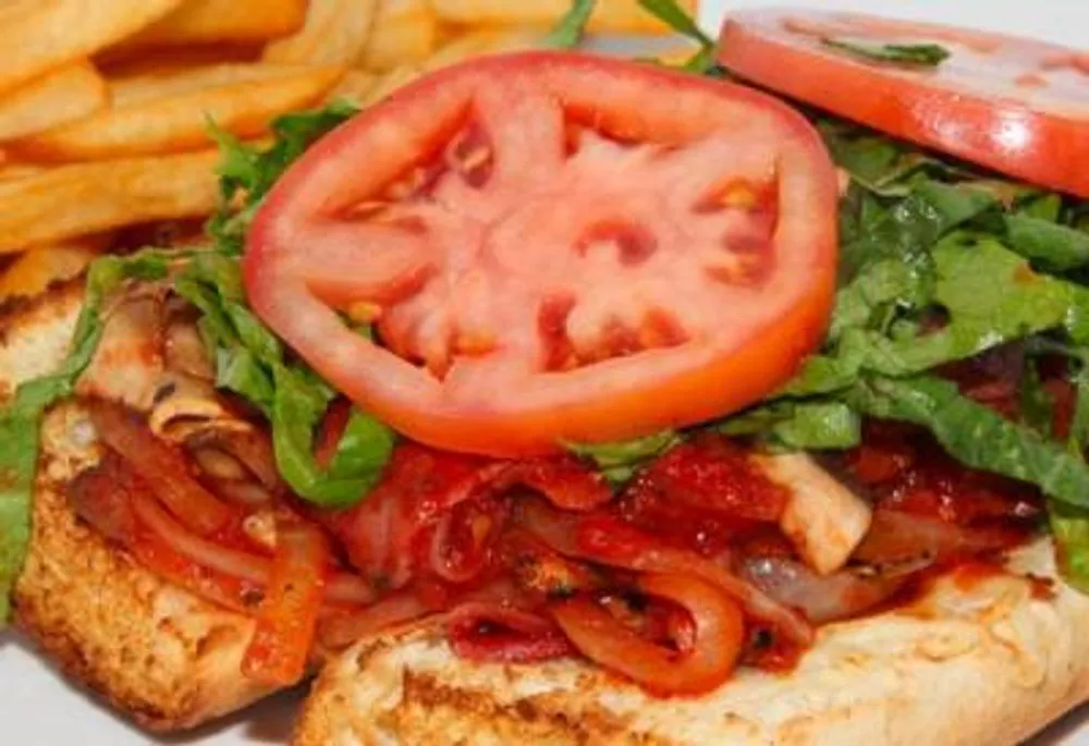 Open-faced toasted sandwich with tomato, leaf greens and caramelized onions at Pizzeria 67, a Pizza Restaurant in Grand-Mère