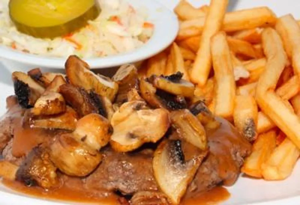 Beef steak smothered in mushroom gravy with fries and coleslaw side at Pizzeria 67, a Pizza Restaurant in Grand-Mère