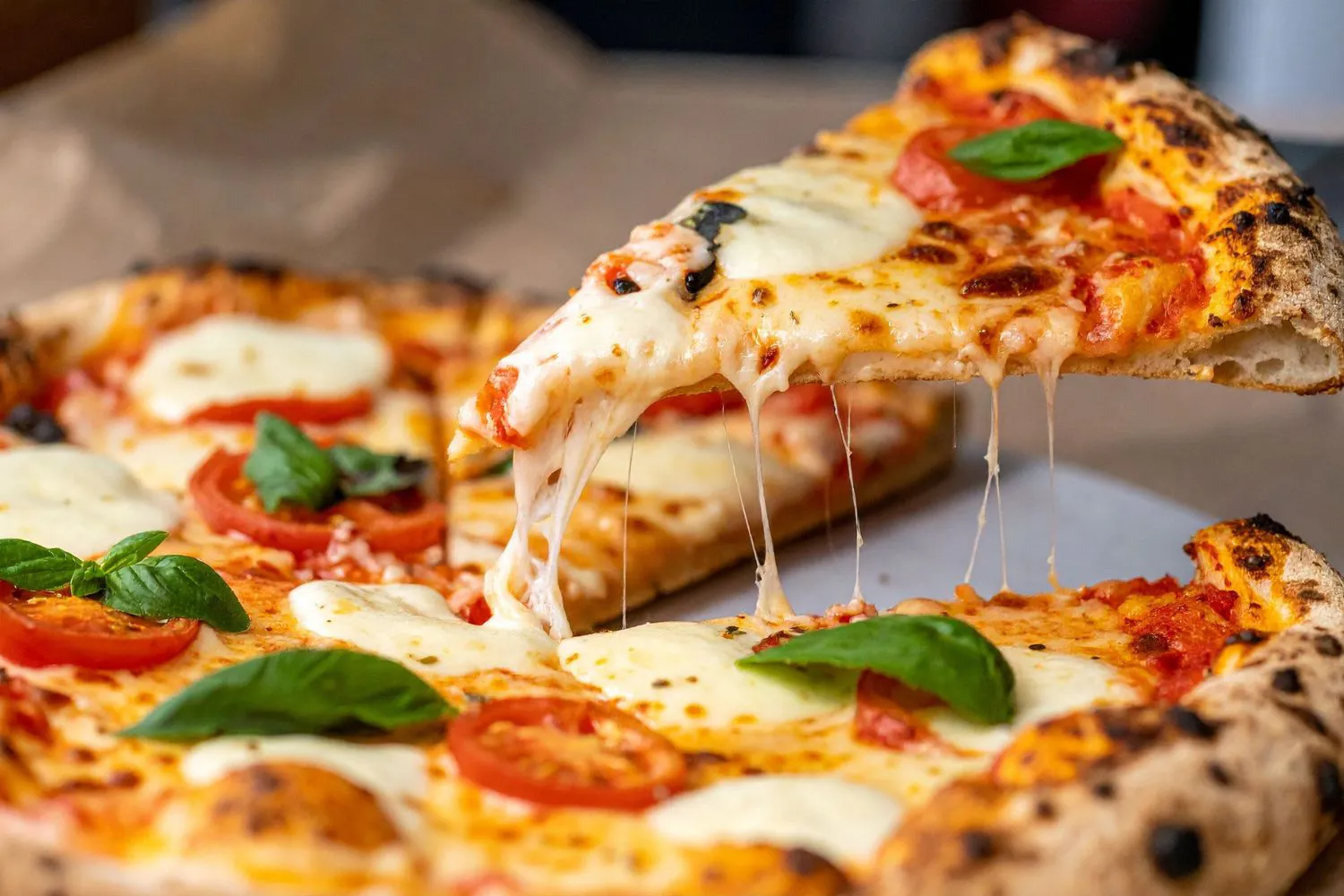 Neapolitan margherita pizza slice with stretchy melted cheese and basil garnish at Pizzeria 67, a Pizza Restaurant in Grand-Mère